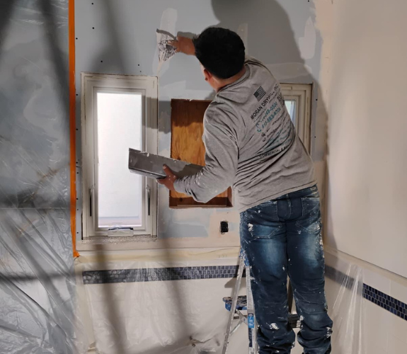 Crew installing drywall with clean Level 5 finish